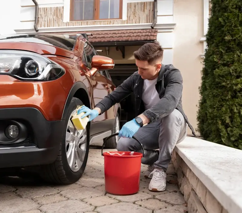 Lavage auto à domicile Pont-l'Évêque : professionnel intervenant sur un véhicule